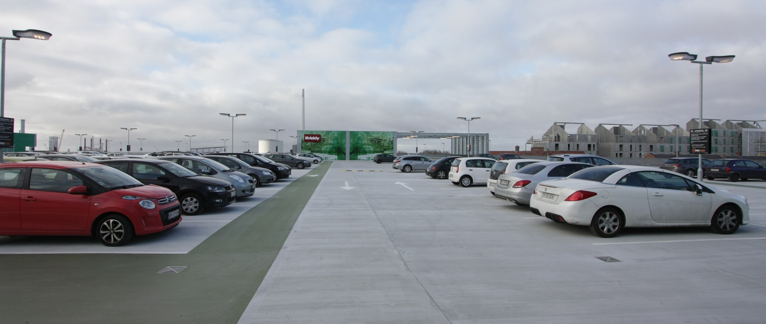 I forhold til traditionelle centre med parkering i bunde, har man her valgt parkering på taget, hvorved kunderne kommer direkte ned på det øvre plan.
